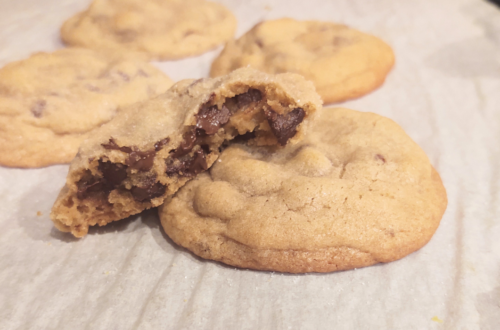 thick and chewy chocolate cookie broken in half on top of another cookie