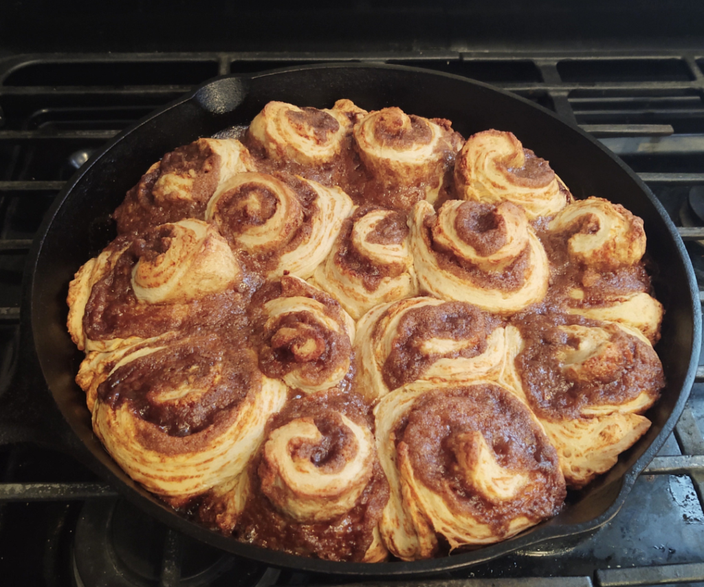 baked sourdough cinnamon rolls on cast iron