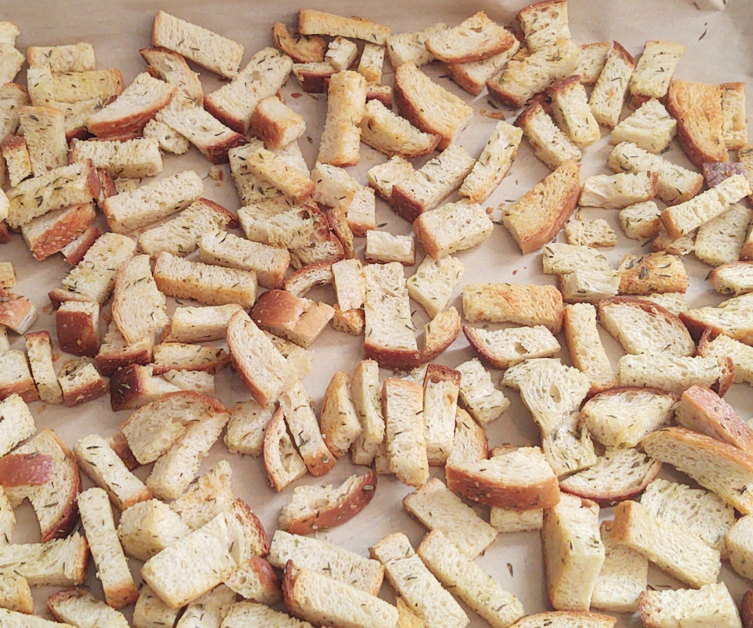pieces of bread on baking pan for sourdough croutons