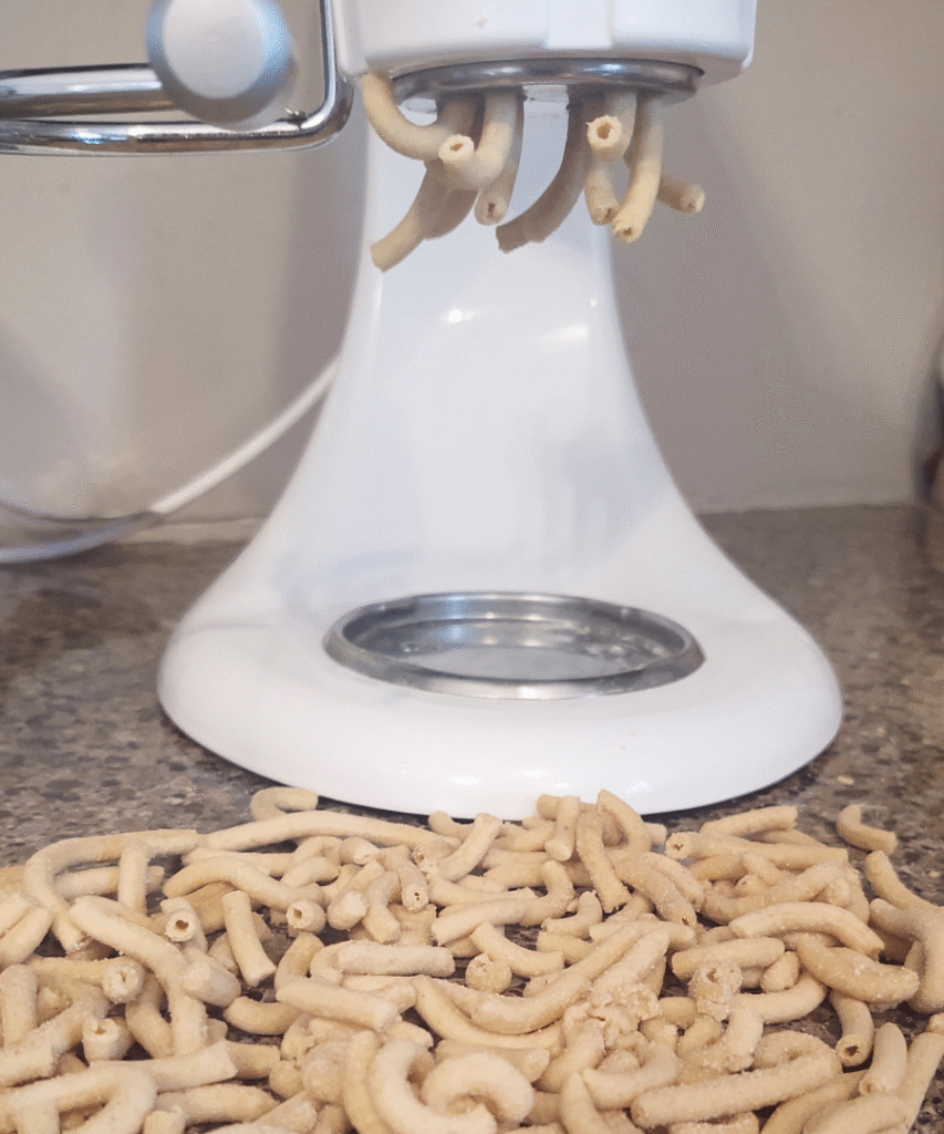 bucatini noodles coming out of machine