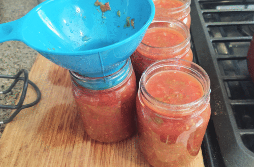 filling jars with fresh salsa